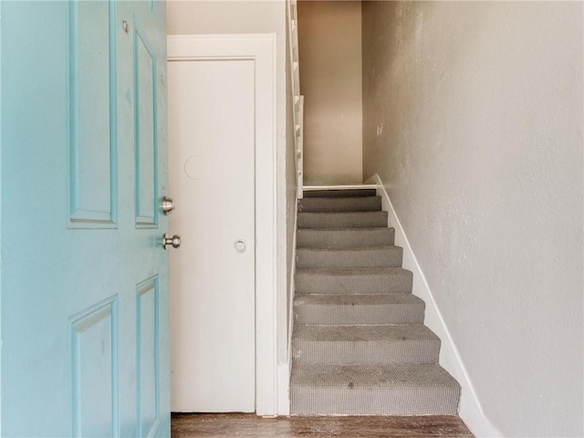 staircase with hardwood / wood-style floors