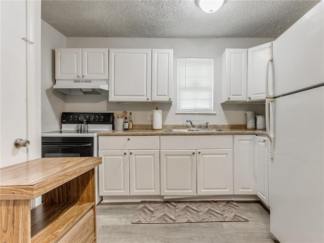 kitchen featuring white cabinets, sink, and white fridge