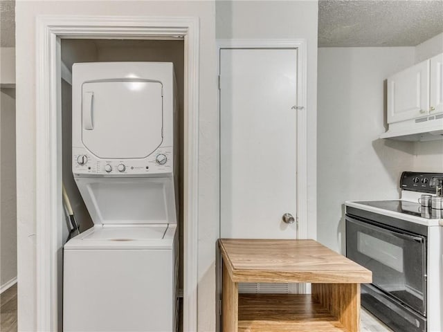 washroom with hardwood / wood-style floors, a textured ceiling, and stacked washing maching and dryer