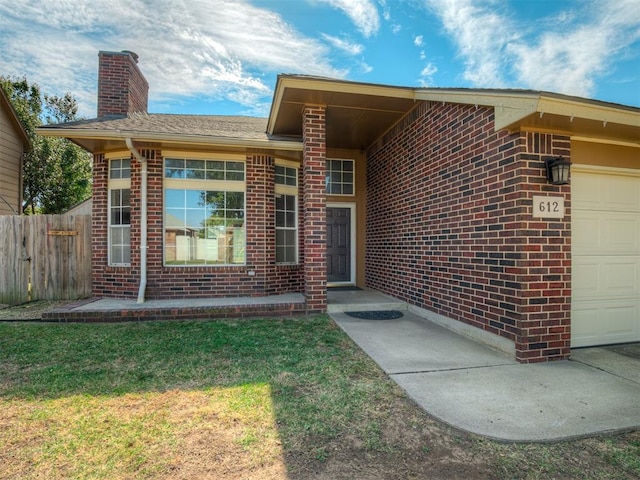 doorway to property featuring a lawn and a garage