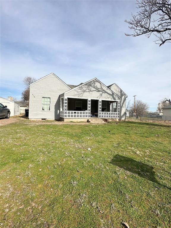 back of house with a lawn and covered porch