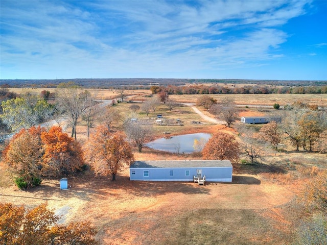 birds eye view of property featuring a water view and a rural view