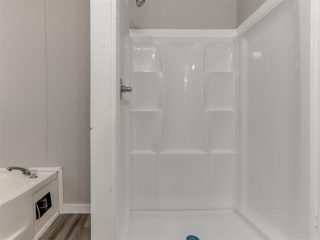 bathroom with hardwood / wood-style floors and a shower