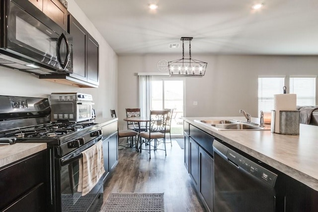 kitchen with black appliances, sink, hanging light fixtures, and a wealth of natural light