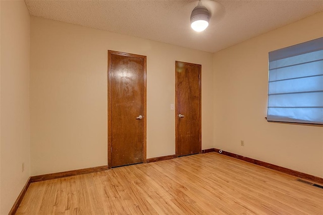 unfurnished bedroom featuring a closet, a textured ceiling, and light wood-type flooring