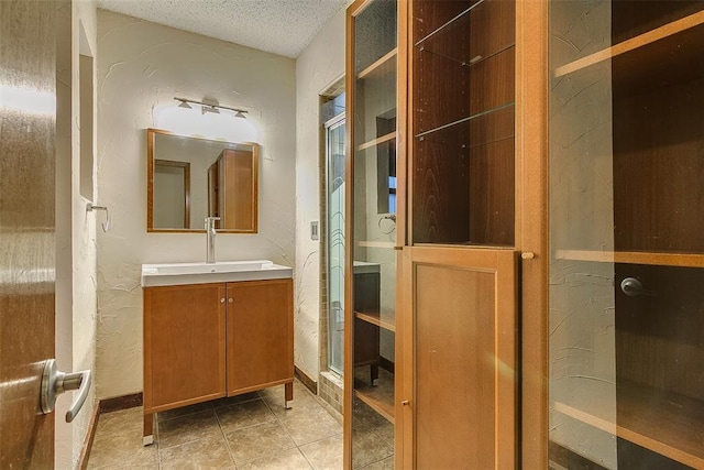 bathroom featuring tile patterned flooring, a textured ceiling, and vanity