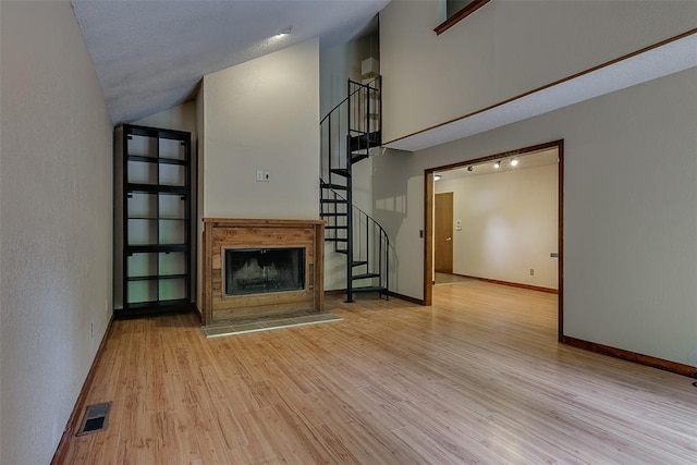 unfurnished living room featuring lofted ceiling and light wood-type flooring