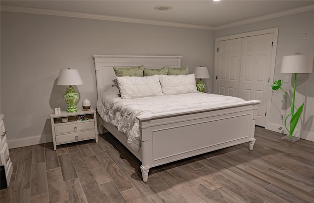 bedroom with crown molding, a closet, and dark wood-type flooring