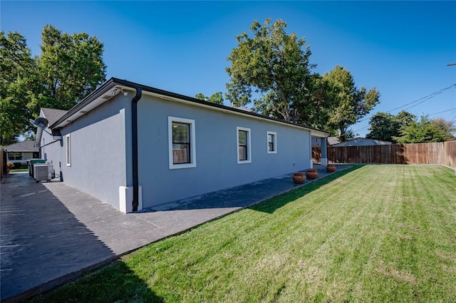 view of side of home with a yard and cooling unit