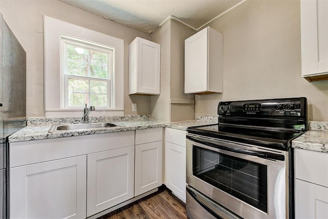 kitchen with white cabinets, sink, electric range, dark hardwood / wood-style floors, and light stone countertops