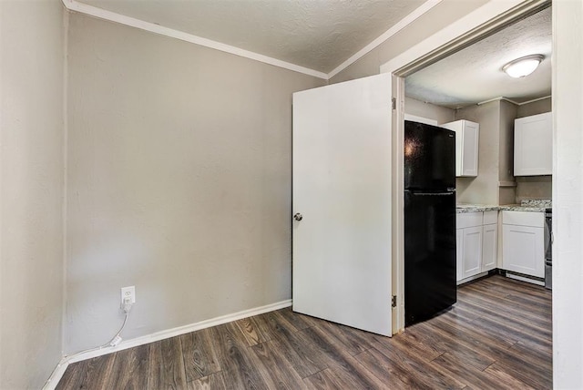 kitchen featuring black refrigerator, dark hardwood / wood-style flooring, ornamental molding, a textured ceiling, and white cabinetry