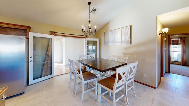 dining space with lofted ceiling, light tile patterned floors, and a chandelier