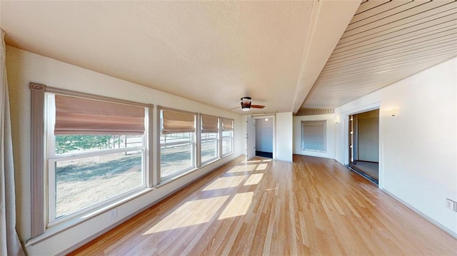 unfurnished sunroom with ceiling fan