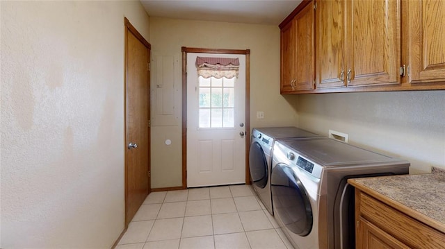 washroom featuring cabinets, light tile patterned floors, and washing machine and dryer