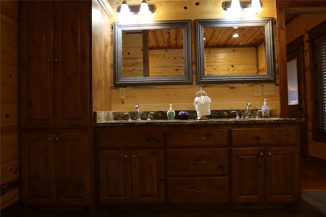 bathroom with vanity and wooden walls