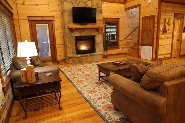 living room featuring wooden walls, a fireplace, and hardwood / wood-style flooring