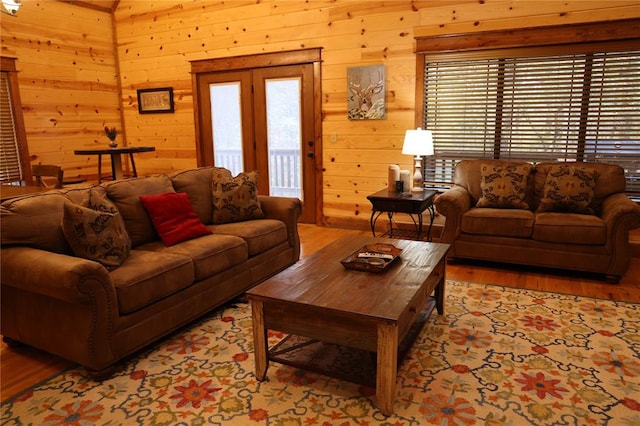 living room with wood walls, a healthy amount of sunlight, and light hardwood / wood-style floors