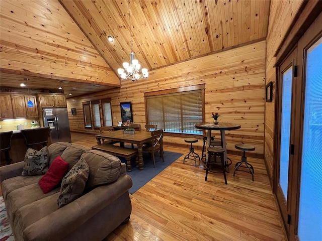 dining area featuring wood walls, high vaulted ceiling, a notable chandelier, light hardwood / wood-style floors, and wood ceiling