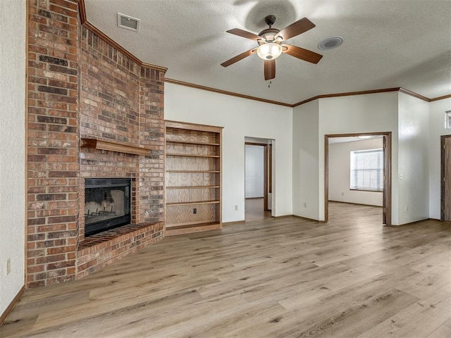 unfurnished living room with a fireplace, a textured ceiling, light hardwood / wood-style flooring, and ceiling fan