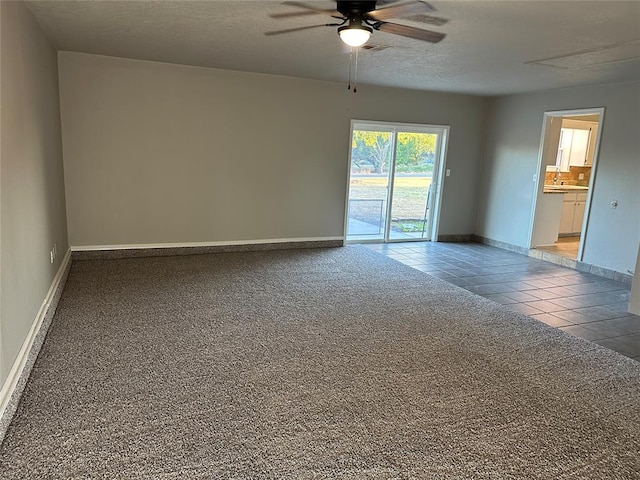 empty room featuring ceiling fan, carpet, and a textured ceiling