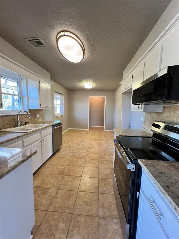 kitchen with white cabinets, a healthy amount of sunlight, sink, and stainless steel appliances