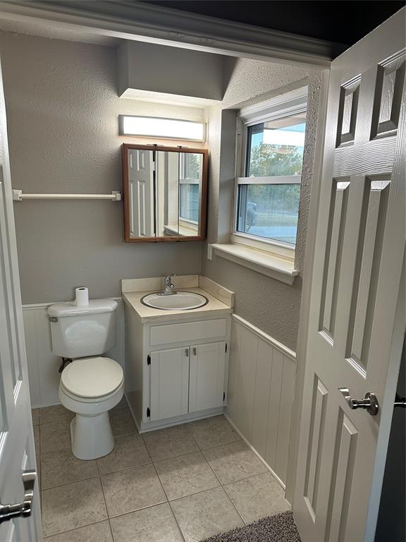 bathroom featuring tile patterned flooring, vanity, and toilet