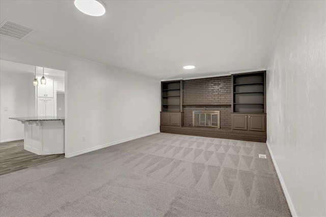 unfurnished living room featuring a fireplace, built in features, and light carpet