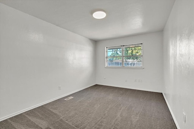 empty room featuring dark carpet