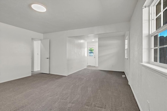 spare room featuring dark colored carpet