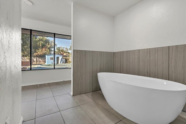 bathroom with tile patterned flooring and a bath