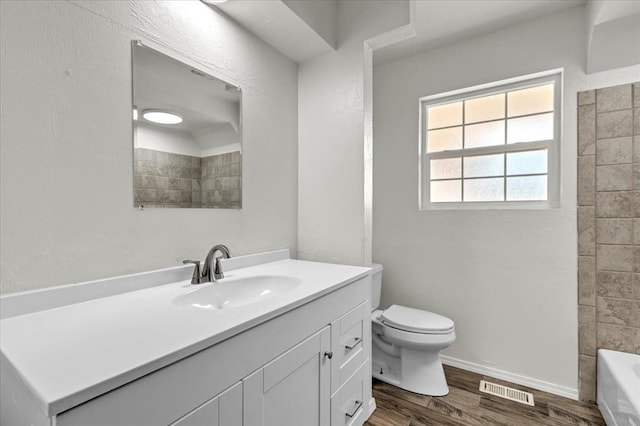 bathroom with hardwood / wood-style flooring, vanity, and toilet