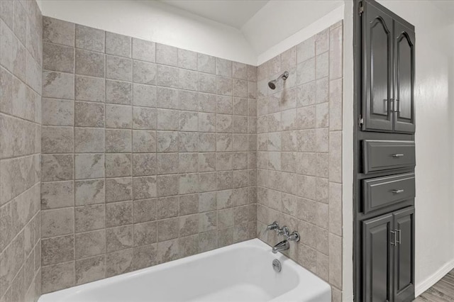 bathroom with tiled shower / bath and vaulted ceiling