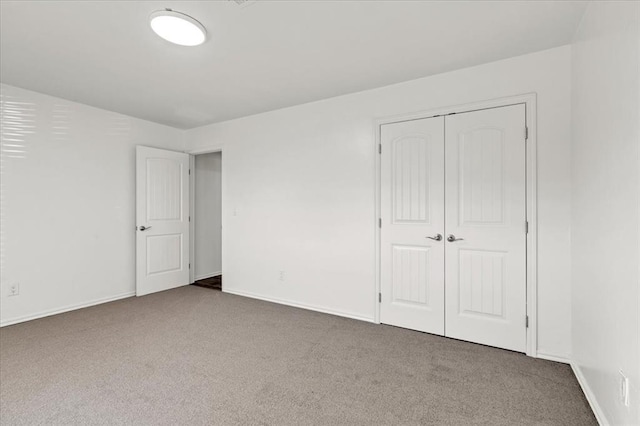 unfurnished bedroom with dark carpet and a closet