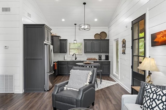 kitchen with stainless steel refrigerator, dark hardwood / wood-style floors, a healthy amount of sunlight, and vaulted ceiling