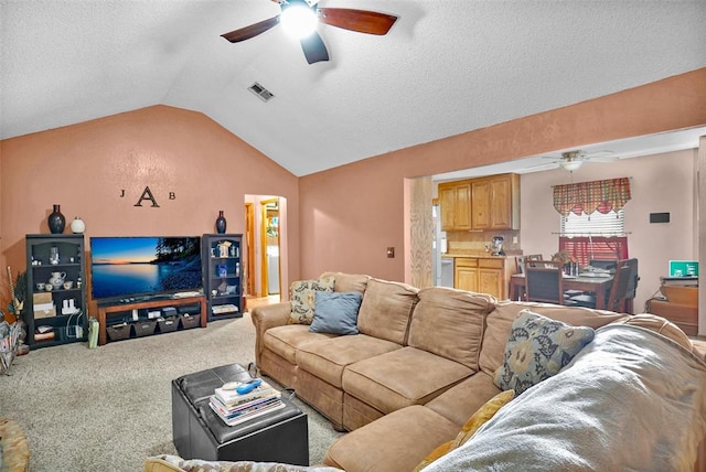 living room with carpet, ceiling fan, lofted ceiling, and a textured ceiling