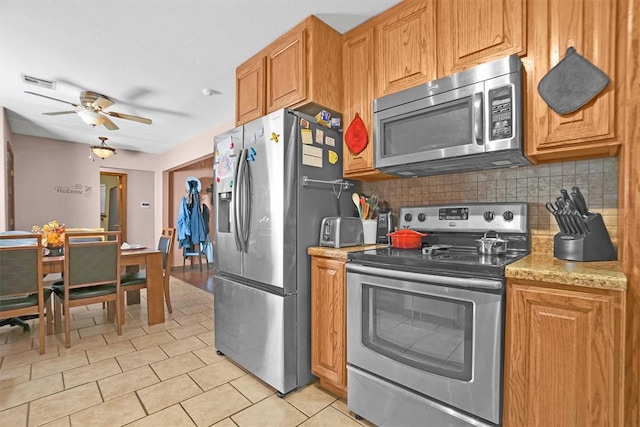 kitchen with tasteful backsplash, stainless steel appliances, and ceiling fan