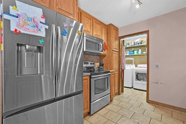 kitchen with washer and dryer, appliances with stainless steel finishes, and tasteful backsplash