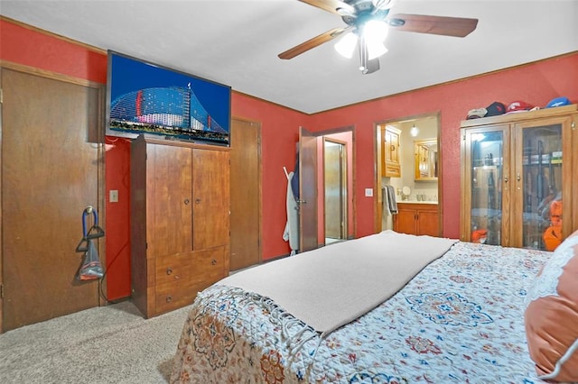 carpeted bedroom with ensuite bath and ceiling fan