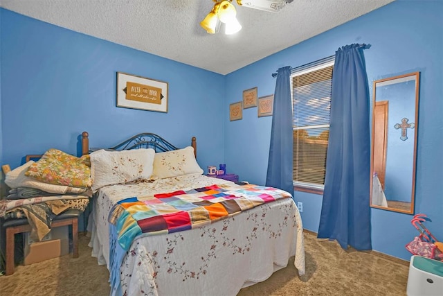 carpeted bedroom with ceiling fan and a textured ceiling