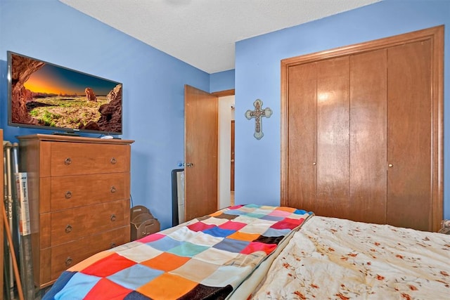 bedroom with a textured ceiling and a closet