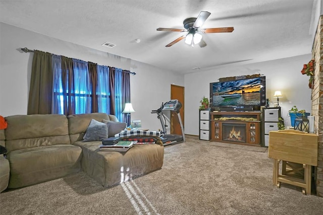 carpeted living room with ceiling fan and a textured ceiling