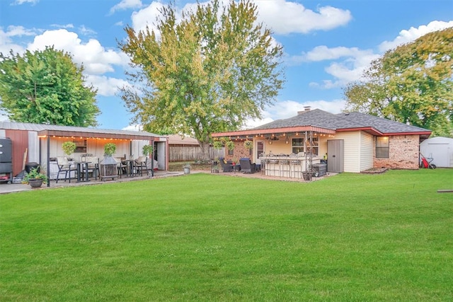 view of yard featuring a patio area, exterior bar, and a shed