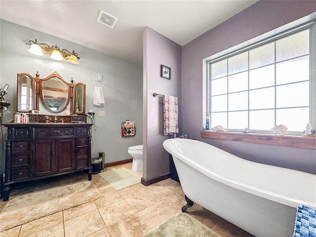 full bathroom featuring baseboards, visible vents, toilet, a soaking tub, and vanity