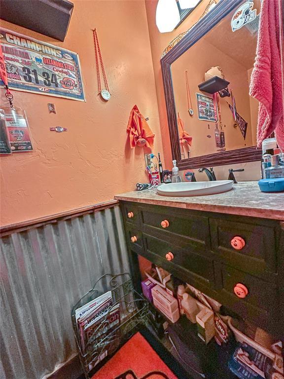 bathroom with a textured wall and vanity