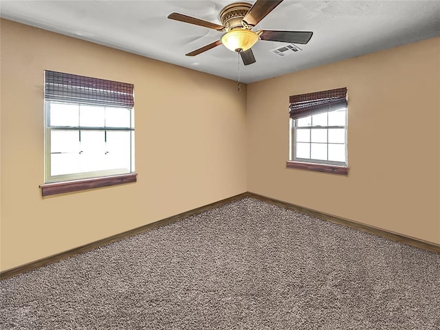 unfurnished room featuring carpet, visible vents, ceiling fan, and baseboards