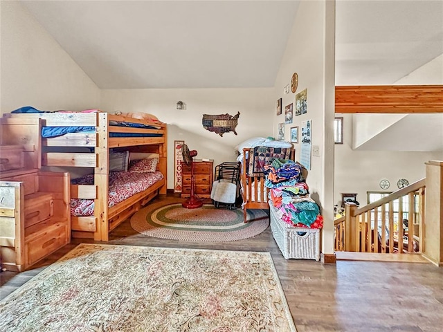 bedroom with vaulted ceiling and wood finished floors