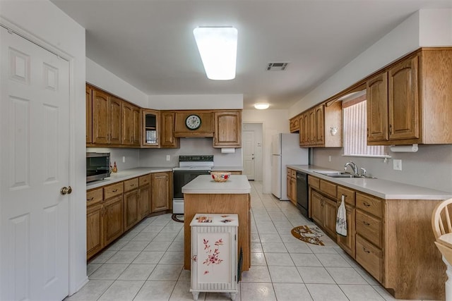 kitchen featuring sink, a kitchen island, white appliances, and light tile patterned floors