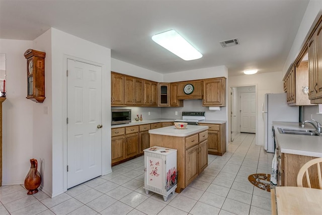 kitchen featuring a center island, sink, electric range oven, white refrigerator, and light tile patterned flooring