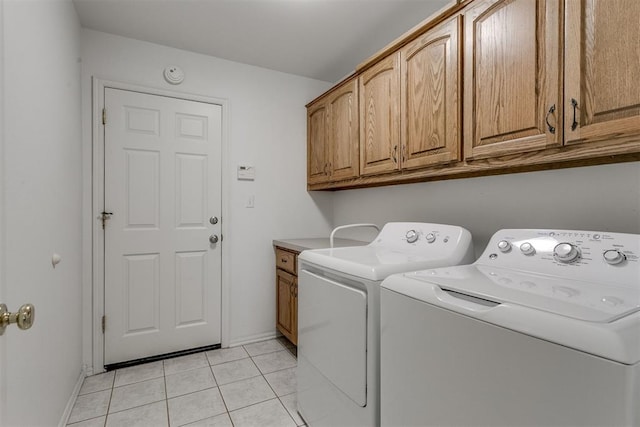 clothes washing area with cabinets, independent washer and dryer, and light tile patterned floors