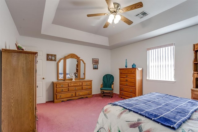 bedroom featuring carpet floors, a raised ceiling, and ceiling fan